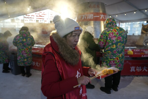 美联社图片：在中国哈尔滨的冰展上，保暖的衣服、火锅甚至雪糕都是一大特色