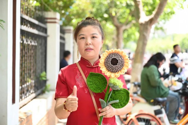 聋哑大妈穿旗袍捧向日葵，无声的温暖，有形的鼓励
