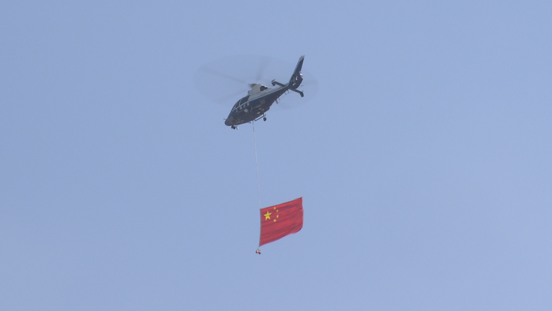 心系中华，翱翔天际—直升机悬挂五星红旗飞越香港上空的庄严时刻